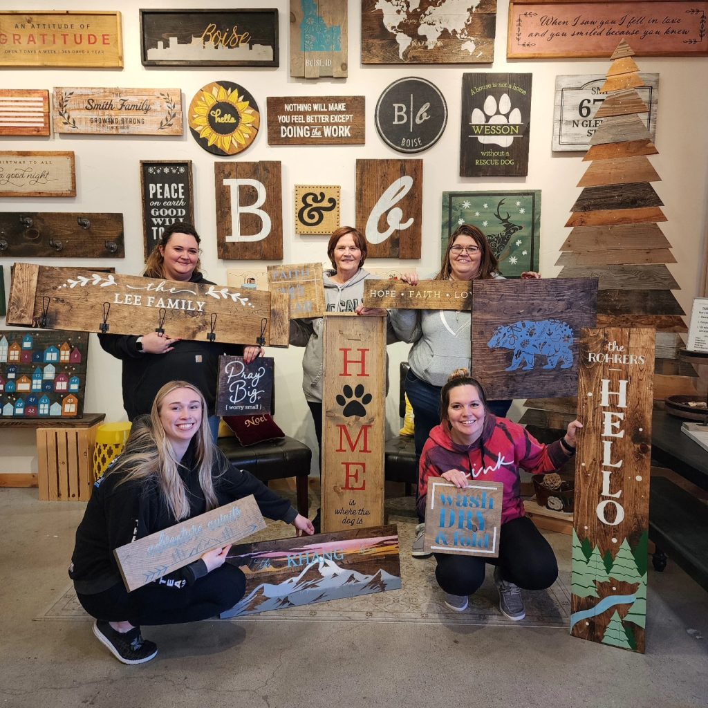 group of women showing their finished wood board and brush craft projects 