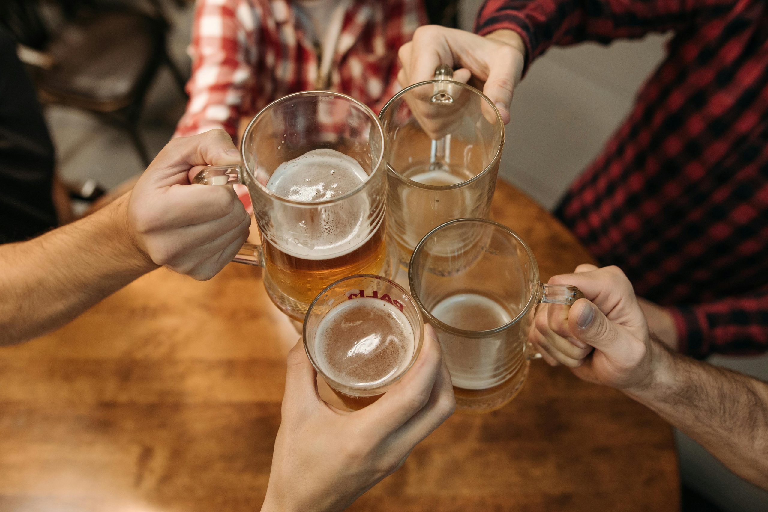 arms toasting with glasses and mugs filled with beer
